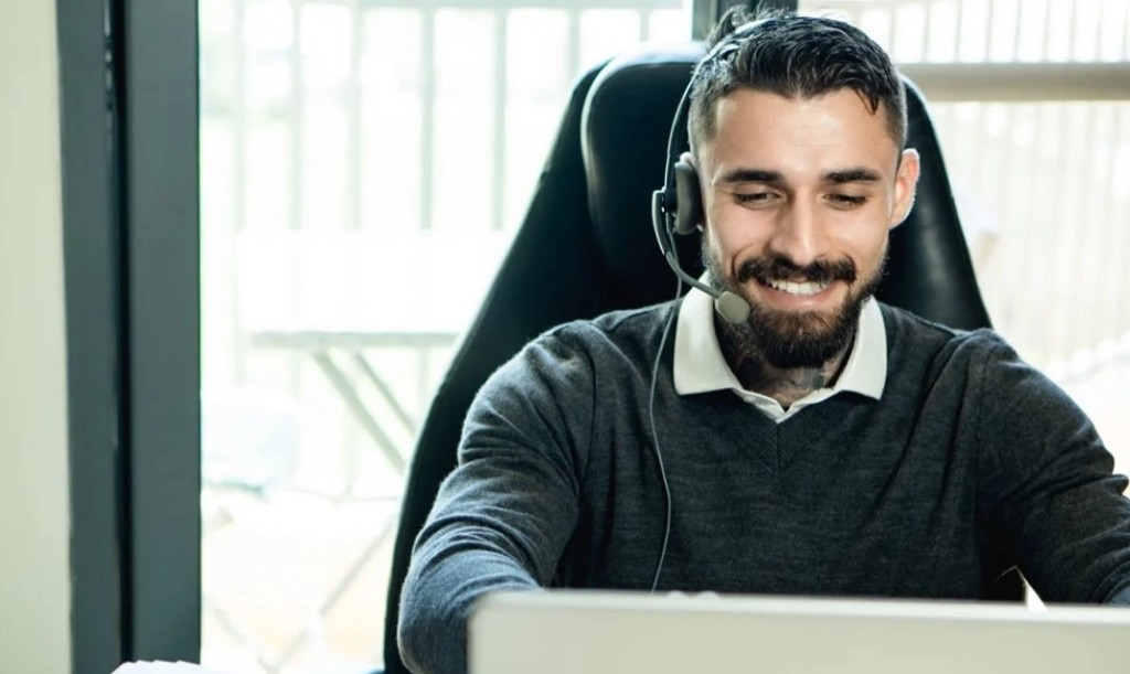 Helpdesk engineer wearing a headset assisting a business telephony customer